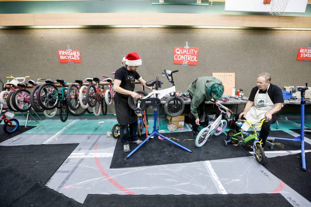 JOHN WOODS / FREE PRESS
Geoff Heath, left, who has been at the event since the beginning, and Dave Elmore, right, fix bikes at the event.