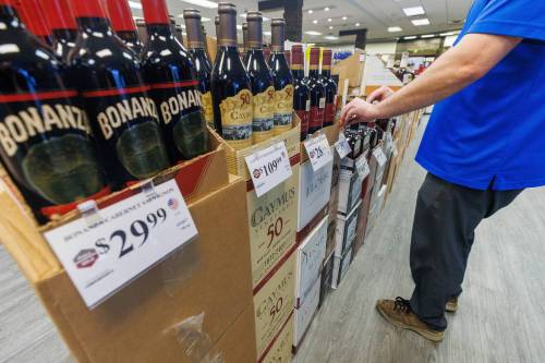 MIKE DEAL / FREE PRESS
                                A Liquor Mart employee puts the final touches on a display of U.S. liquor about to go on sale at the Crestview store Wednesday morning.