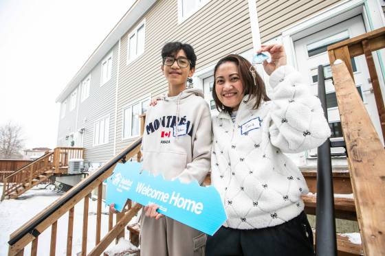 Jacq Roxas (right) and her son, Asher Roxas, hold the keys to their new Habitat for Humanity home on Pandora Avenue West on Monday. (Mikaela MacKenzie / Free Press)