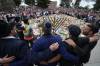 Mark Baker / the Associated Press 
                                Mourners gather at a menorah lighting ceremony at a floral memorial for victims of the Bondi Beach shooting.