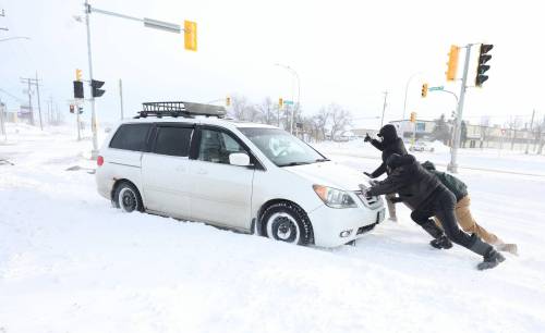 RUTH BONNEVILLE / FREE PRESS
                                 Drivers that were passing by a van stuck along Dugald Road stopped to help the driver.