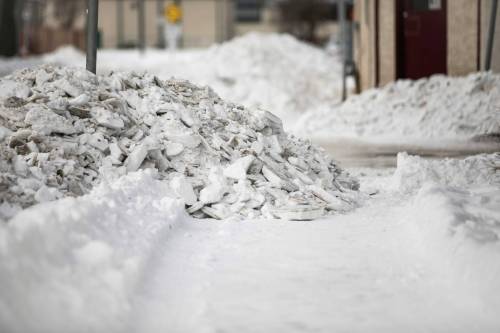 MIKAELA MACKENZIE / FREE PRESS
                                Windrows pile across sidewalks on Wolever Avenue after snow clearing.