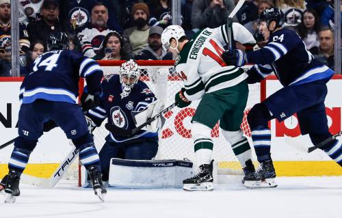 JOHN WOODS / THE CANADIAN PRESS
                                Winnipeg Jets goaltender Connor Hellebuyck gets his glove on the puck as Minnesota Wild&rsquo;s Joel Eriksson Ek tries to knock it in.