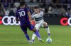 Vancouver Whitecaps defender Tate Johnson, right, is defended by Orlando City midfielder Martín Ojeda (10) during the first half of an MLS soccer match, Saturday, Oct. 11, 2025, in Orlando, Fla. (AP Photo/Kevin Kolczynski)