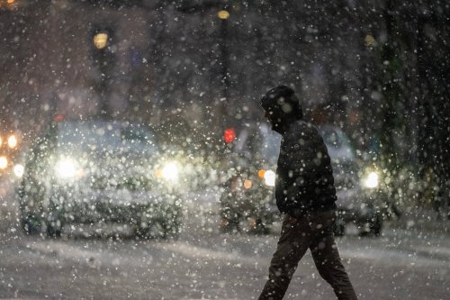 A man crosses 7th street in the heavy snow Sunday Dec. 28, 2025 in downtown Minneapolis. (Jerry Holt /Star Tribune via AP)