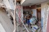 Jonathan Mayoral helps relatives clean up their apartment, which residents say was damaged during U.S. military operations to capture Venezuelan President Nicolás Maduro, in Catia La Mar, Venezuela, Sunday, Jan. 4, 2026. (AP Photo/Matias Delacroix)