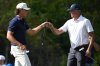 Matt Kuchar, right, gets a fist bump from his son Cameron Kuchar after sinking an eagle putt on the third green during the final round of the PNC Championship golf tournament, Sunday, Dec. 21, 2025, in Orlando, Fla. (AP Photo/Phelan M. Ebenhack)