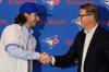 Dylan Cease pitcher for the Toronto Blue Jays shakes hands with Ross Atkins general manager of the Toronto Blue Jays, after he was presented with a team hat and jersey during a news conference at the Major League Baseball's winter meetings, Tuesday, Dec. 9, 2025, in Orlando, Fla. (AP Photo/John Raoux)