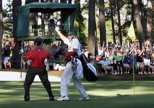 FILE - Tiger Woods celebrates with his caddie Steve Williams, right, after his chip-in birdie on 16th hole during the 2005 Masters at the Augusta National Golf Club, in Augusta, Ga., Sunday, April 10, 2005. (AP Photo/Elise Amendola, File)