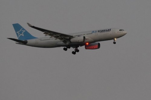 An Air Transat Airbus A330 approaches for landing in Lisbon just before sunrise, Monday, July 22, 2024. (AP Photo/Armando Franca)