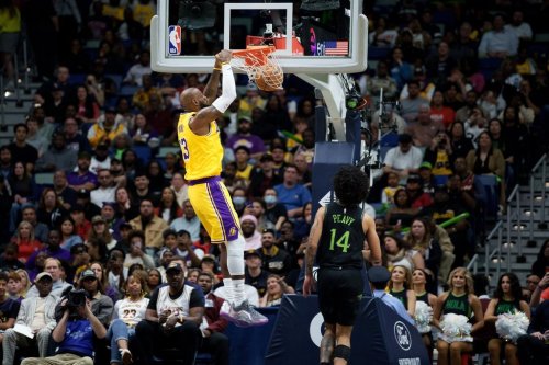 Los Angeles Lakers forward LeBron James (23) dunks next to New Orleans Pelicans guard Micah Peavy (14) during the first half of an NBA basketball game in New Orleans, Tuesday, Jan. 6, 2026. (AP Photo/Matthew Hinton)