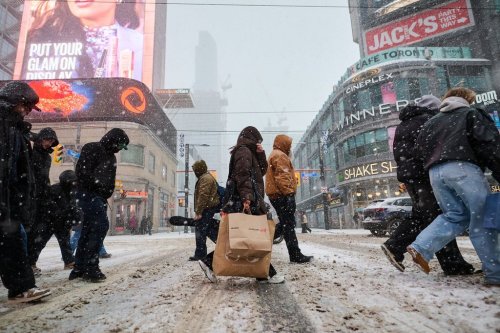 Shoppers walk through a snow storm as they exit Eaton Centre on Boxing Day in Toronto, on Friday, Dec. 26, 2025. THE CANADIAN PRESS/Sammy Kogan