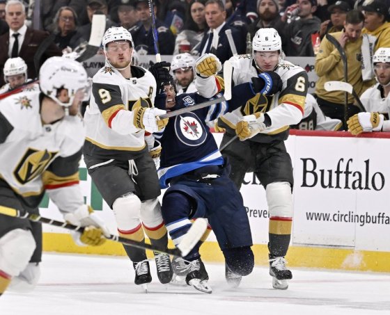 Vegas Golden Knights' Jack Eichel (9) and Kaedan Korczak (6) check Winnipeg Jets' Morgan Barron during the two teams' last match-up on Jan. 6. (Fred Greenslade / The Canadian Press files)