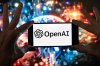 FILE - The OpenAI logo is seen displayed on a cell phone in front of an image on a computer screen generated by ChatGPT's Dall-E text-to-image model, Friday, Dec. 8, 2023, in Boston. (AP Photo/Michael Dwyer, file)