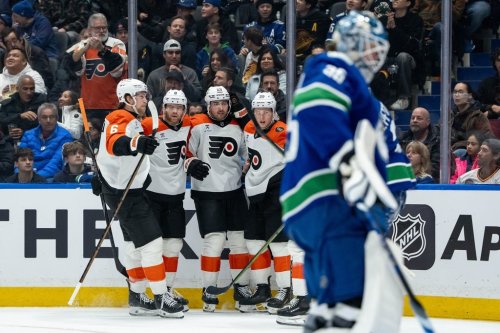 Philadelphia Flyers' Noah Cates (27) celebrates his goal against the Vancouver Canucks with Travis Sanheim (6), Cam York (8) and Matvei Michkov (39) as Canucks goaltender Thatcher Demko (35) looks on during first period NHL action in Vancouver, on Tuesday, Dec. 30, 2025. THE CANADIAN PRESS/Ethan Cairns