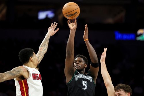 Minnesota Timberwolves guard Anthony Edwards (5) shoots between Miami Heat center Kel'el Ware, left, and guard Pelle Larsson, right, during the first half of an NBA basketball game, Tuesday, Jan. 6, 2026, in Minneapolis. (AP Photo/Ellen Schmidt)