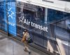 A traveller walks past an Air Transat logo in departures at Montreal-Pierre Elliott Trudeau International Airport in Montreal on Tuesday, Dec. 9, 2025. THE CANADIAN PRESS/Christinne Muschi