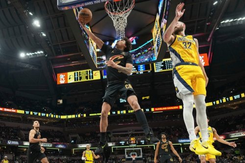 Cleveland Cavaliers guard Craig Porter Jr., left, shoots after going around Indiana Pacers center Jay Huff during the first half of an NBA basketball game in Indianapolis, Tuesday, Jan. 6, 2026. (AP Photo/AJ Mast)