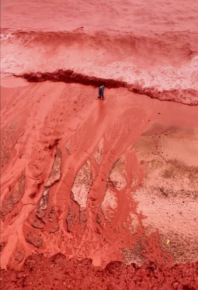 This picture, taken from video, shows how rainfall briefly transforms the coastline of its famed Red Beach into a striking natural scene on Iran's Hormuz Island, Tuesday Dec. 16, 2025. (AP Photo)