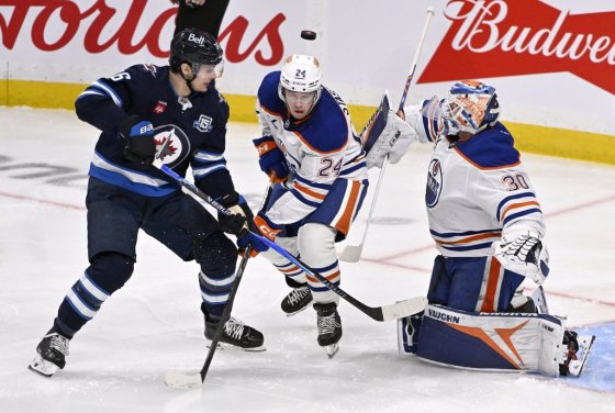 Edmonton Oilers goaltender Calvin Pickard (30) makes a save as Winnipeg Jets' Morgan Barron (36) and Oilers' Spencer Stastney (24) look for the rebound in Winnipeg on Monday. (Fred Greenslade / The Canadian Press files)