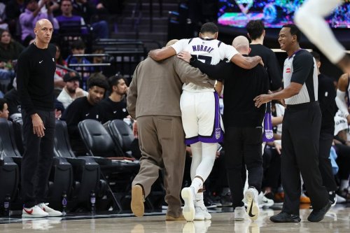 Sacramento Kings forward Keegan Murray, center, is helped to the locker room after a left ankle injury during the second half of an NBA basketball game against the Milwaukee Bucks Sunday, Jan. 4, 2026, in Sacramento, Calif. (AP Photo/Sara Nevis)