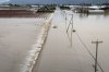 A car crosses a flooded street in Abbotsford B.C., on Thursday, Dec. 11, 2025. THE CANADIAN PRESS/Ethan Cairns
