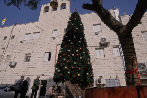 Palestinian parishioners check a recently installed Christmas tree after the previous one was destroyed at the Holy Redeemer Latin Church in the West Bank town of Jenin, Tuesday, Dec. 23, 2025. (AP Photo/Majdi Mohammed)