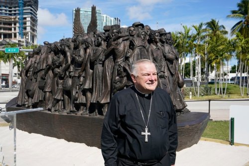 FILE - Archbishop of Miami Thomas Wenski poses in front of a traveling bronze sculpture titled 