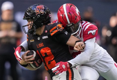 B.C. Lions quarterback Nathan Rourke, front left, is sacked by Calgary Stampeders' Clarence Hicks during the first half of a CFL football game, in Vancouver, on Saturday, October 4, 2025. THE CANADIAN PRESS/Darryl Dyck