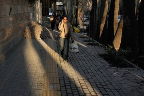 People walk along the sidewalk in northern Tehran, Iran, Tuesday, Jan. 27, 2026. (AP Photo/Vahid Salemi)