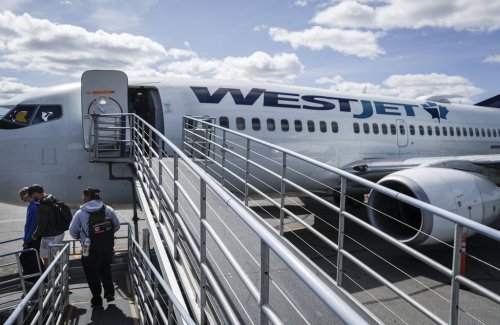 WestJet passengers deplane on the tarmac at Yellowknife Airport on Tuesday, July 22, 2025. THE CANADIAN PRESS/Jeff McIntosh