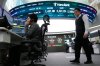 A currency trader talks on the phone near a screen showing the Korea Composite Stock Price Index (KOSPI), top center, and the foreign exchange rate between U.S. dollar and South Korean won, top center left, at the foreign exchange dealing room of the Hana Bank headquarters in Seoul, South Korea, Friday, Jan. 30, 2026. (AP Photo/Ahn Young-joon)