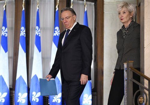 Quebec Premier François Legault and his wife Isabelle Brais walk to a news conference to announce his resignation in Quebec City Wednesday, Jan. 14, 2026. THE CANADIAN PRESS/Jacques Boissinot