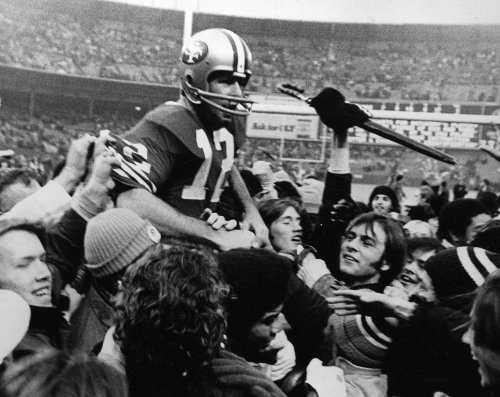 FILE - John Brodie, veteran San Francisco 49ers quarterback, gets a free ride on the shoulders of an admiring crowd following their win over the Minnesota Vikings that gave the 49ers the Western Division championship in San Francisco, Dec. 16, 1972. (AP Photo, File)