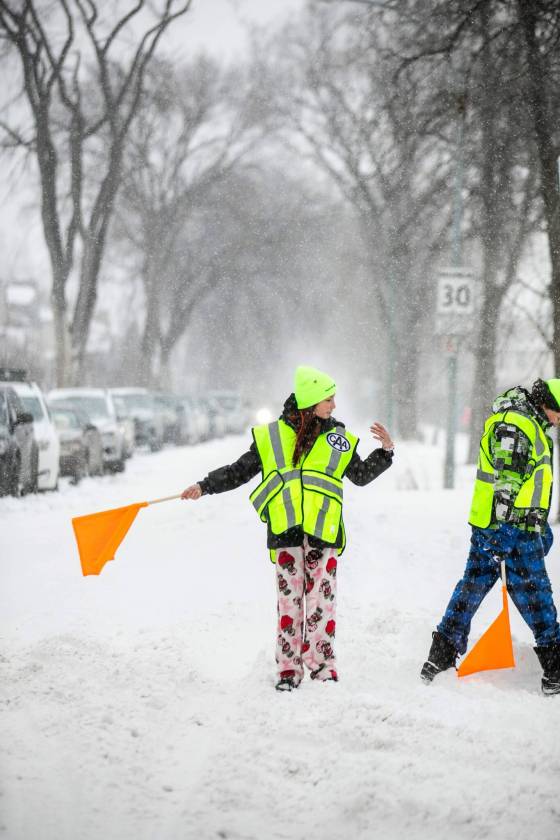 School patrols Mariah (left) and Oliver demonstrate what they would usually do at Isaac Brock School as safety patrol members. (Mikaela MacKenzie / Free Press)