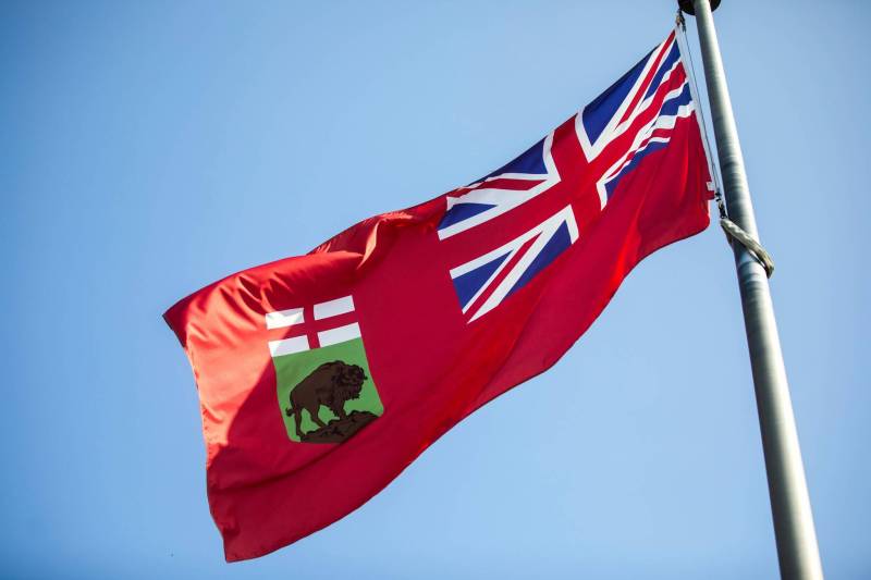 MIKAELA MACKENZIE / WINNIPEG FREE PRESS 	 The Manitoba flag flies in front of the Manitoba Legislative Building on Monday, Aug. 19, 2024. According to a Probe Research poll, 49% of Manitobans would support creating a new flag for the province. Winnipeg Free Press 2024