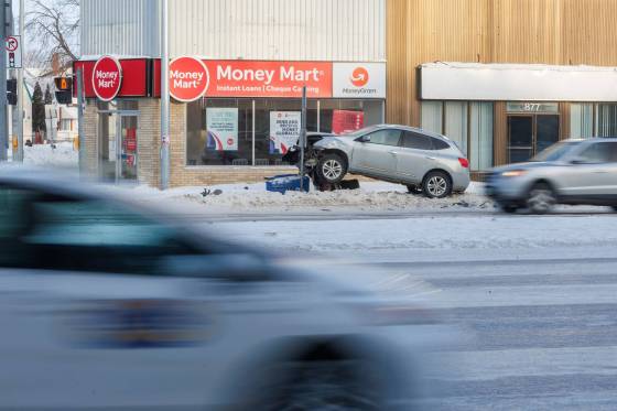 A vehicle sits up on the curb near the slippery intersection of Portage Avenue and Arlington Street on Thursday morning. (Mike Deal / Free Press)