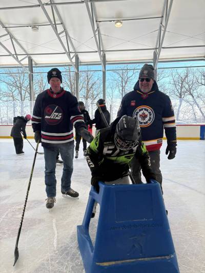 MELISSA MARTIN / FREE PRESS
                                Winnipeg Jets organization alumni Gerard McDonald and longtime NHL goalie Trevor Kidd, who is Métis from Oakbank, give skating tips to 12-year-old Savion Grieves, from Bunibonibee Cree Nation.