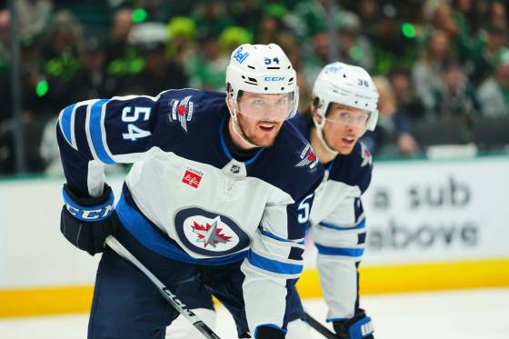 Winnipeg Jets defenceman Dylan Samberg’s (left) calm demeanour has helped in his new role as mentor for the up-and-coming players on the roster.(Julio Cortez / The Associated Press files)