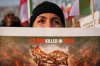 A woman cries as members of the Iranian community stage a rally in support of anti-government protests in Iran, outside the U.S. embassy in Bucharest, Romania, Wednesday, Jan. 14, 2026. (AP Photo/Andreea Alexandru)