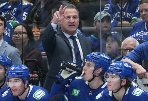 Vancouver Canucks head coach Adam Foote, back, gestures while standing on the bench behind Drew O’Connor, front left to right, Jonathan Lekkerimaki and Braeden Cootes during the first period of an NHL hockey game against the St. Louis Blues, in Vancouver, on Monday, Oct. 13, 2025. THE CANADIAN PRESS/Darryl Dyck