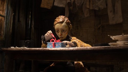 A character opens a gift in an undated still frame handout image from the film 