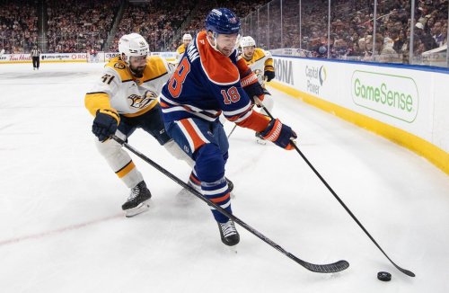 Nashville Predators' Nicolas Hague (41) and Edmonton Oilers' Zach Hyman (18) battle for the puck during second period NHL action, in Edmonton on Tuesday, January 6, 2026. THE CANADIAN PRESS/Jason Franson