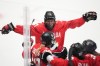Daryl Watts of Canada, down, celebrates with teammates after scoring her sides fourth goal during the semi final match between Canada and Finland at the Women's Ice Hockey Championships in Ceske Budejovice, Czech Republic, Saturday, April 19, 2025. (AP Photo/Petr David Josek)