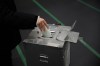 A voter fills in a ballot in the upper house election at a polling station Sunday, Feb. 8, 2026, in Tokyo. (AP Photo/Louise Delmotte)