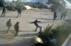 This frame grab from security camera footage filmed Jan. 8, 2025, and obtained by The Associated Press, shows men dressed mostly in black with their faces covered, one of whom is kicking a man on the ground as he tried to flee a nursery in the northern West Bank village of Deir Sharaf. Two people who witnessed the attack and are members of the family that owns the facility said the assailants were Israeli settlers beating 67-year-old Basim Saleh Yassin.(UGC via AP)