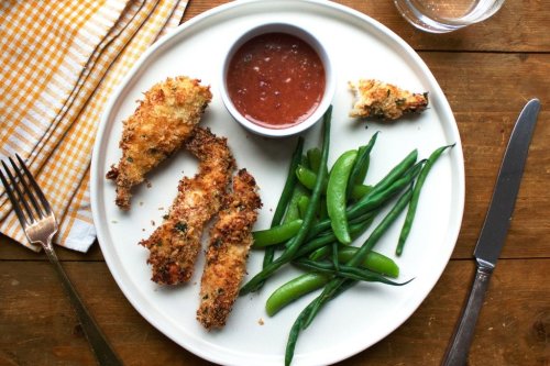 This image shows a recipe for crispy chicken strips with an apricot mustard dipping sauce. (Katie Workman via AP)
