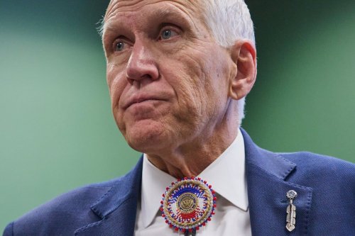 FILE - Wearing a beaded bolo around a pin that says 