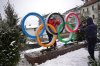 A woman poses for a photo with the Olympic rings ahead of the Olympic Winter Games Milano Cortina 2026, in Cortina d'Ampezzo, Italy, Wednesday, Feb. 4, 2026. (AP Photo/Fatima Shbair)