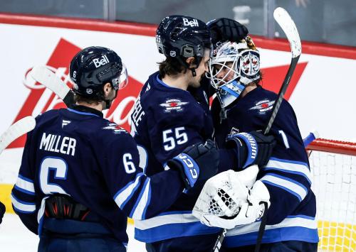 Winnipeg Jets' Mark Scheifele (55) congratulates goaltender Eric Comrie (1) for the win over the Los Angeles Kings in NHL action in Winnipeg, Friday, January 9, 2026. THE CANADIAN PRESS/John Woods